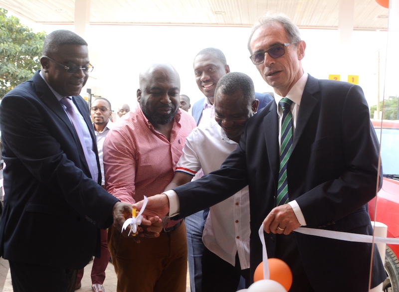 Mr. Bernard Le Goff (right) being assisted by Mr. Ebenezer Faulkner (left) and others to officially open the Westlands Shell service station