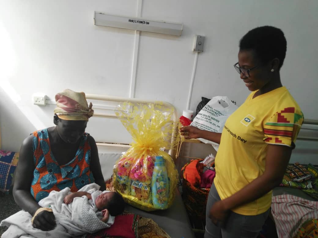 MTN vounteer presenting a baby hamper to a mother and her baby at Koforidua.