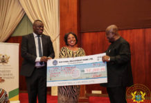 President Akufo-Addo presenting a cheque to one of the beneficiaries